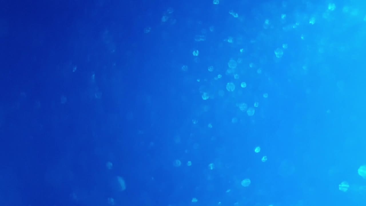 color azul profundo del océano con brillo giratorio y burbujas que parpadean y dan pulsos de luz a medida que se mueven, gran fondo calmante