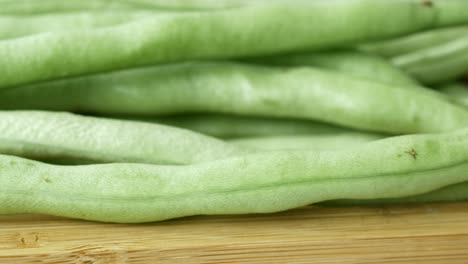 frijoles verdes frescos en una tabla de corte de bambú