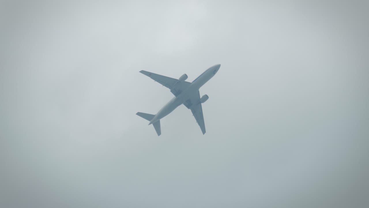 Close-Up of an Airplane Flying Low in the Sky Above People in Slow Motion