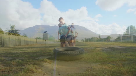 playing on tire swing, two children enjoying animation in open field with mountains