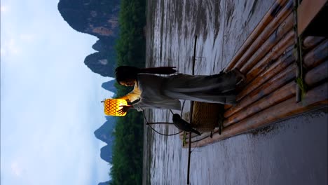 niña hanfu con una linterna iluminada en una balsa en el río li al anochecer