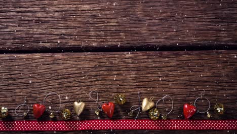 Falling-snow-with-Christmas-decorations-on-wood