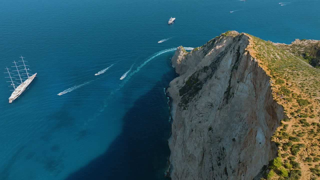 Aerial view of a yacht and boats near a cliff in Greece