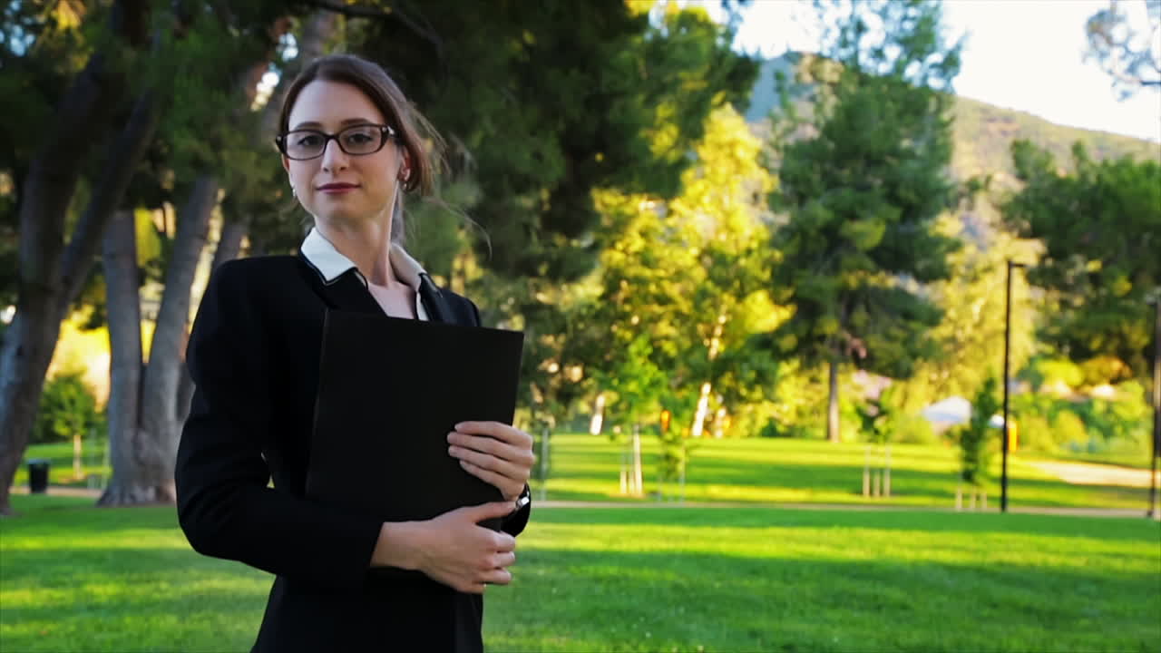 atractiva mujer de negocios caucásica mira a la cámara con una expresión de orgullo y confianza con una ligera sonrisa