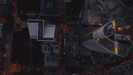 AERIAL:-Beautiful-rise-up-Shot-between-huge-Skyscrapers-in-European-City-Frankfurt-am-Main-with-glowing-street-lights-and-little-traffic-due-to-Coronavirus-Covid-19-Pandemic