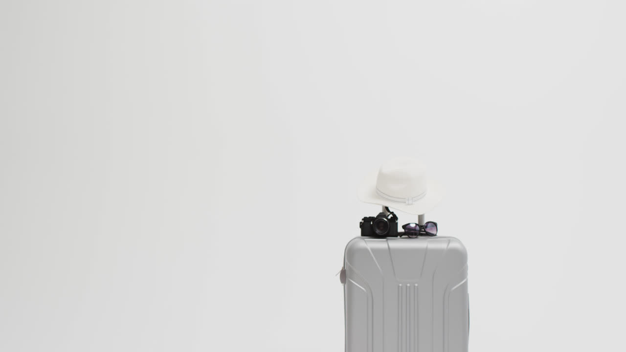 primer plano de la maleta, la cámara, las gafas de sol y el sombrero de sol con espacio de copia sobre un fondo blanco