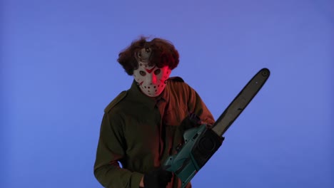 man in white mask with chainsaw in hands on blue background image of maniac jason voorhees from