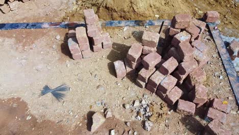 Construction-using-earthen-blocks,-Building-the-foundation-of-the-house,-Workers-work-at-a-construction-site-in-India,-Building-a-house-with-red-stone-,-Works-using-cement-