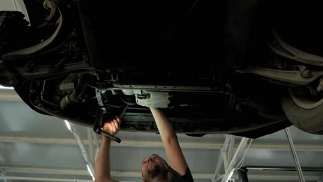 mecánico trabajando debajo de un coche