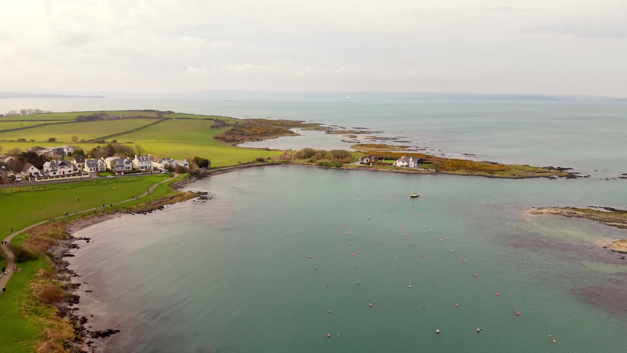 Video aereo in 4K a 60FPS dall'alto del villaggio e della spiaggia di Groomsport nella Contea di Down, Irlanda del Nord. Prodotto con colori Rec709