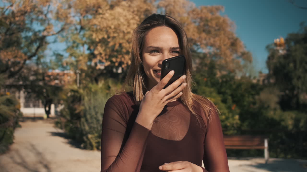 Jovem mulher usando smartphone ao ar livre.