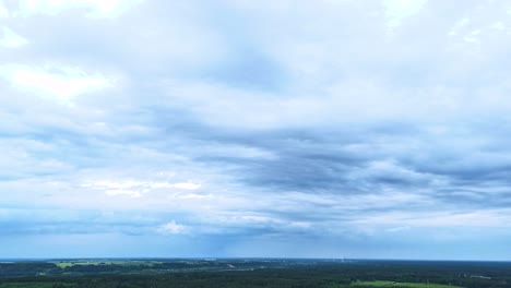 stormy clouds flowing over flat lithuanian landscape, aerial time lapse view