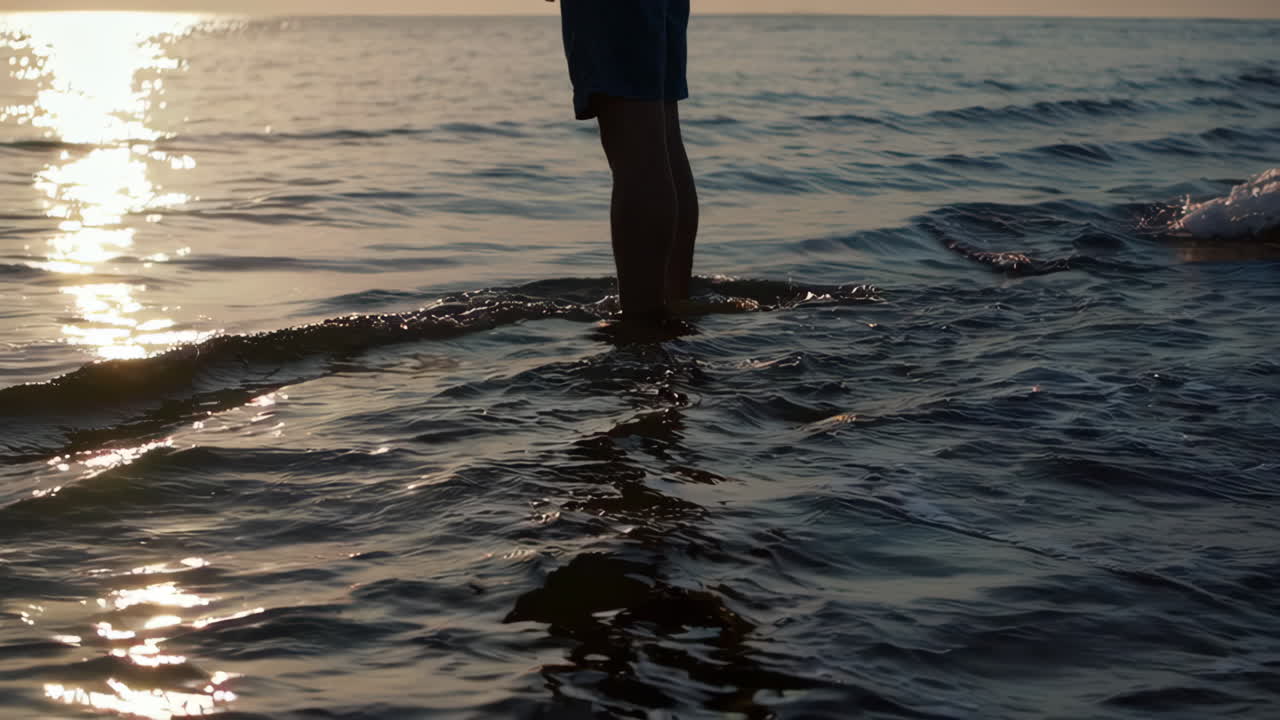 Person Standing in Ocean Water at Sunset