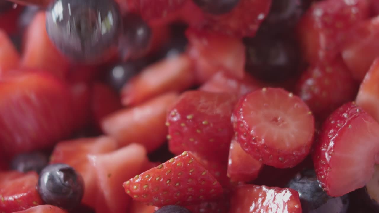 fresas y arándanos mezclados en un bol, cámara lenta