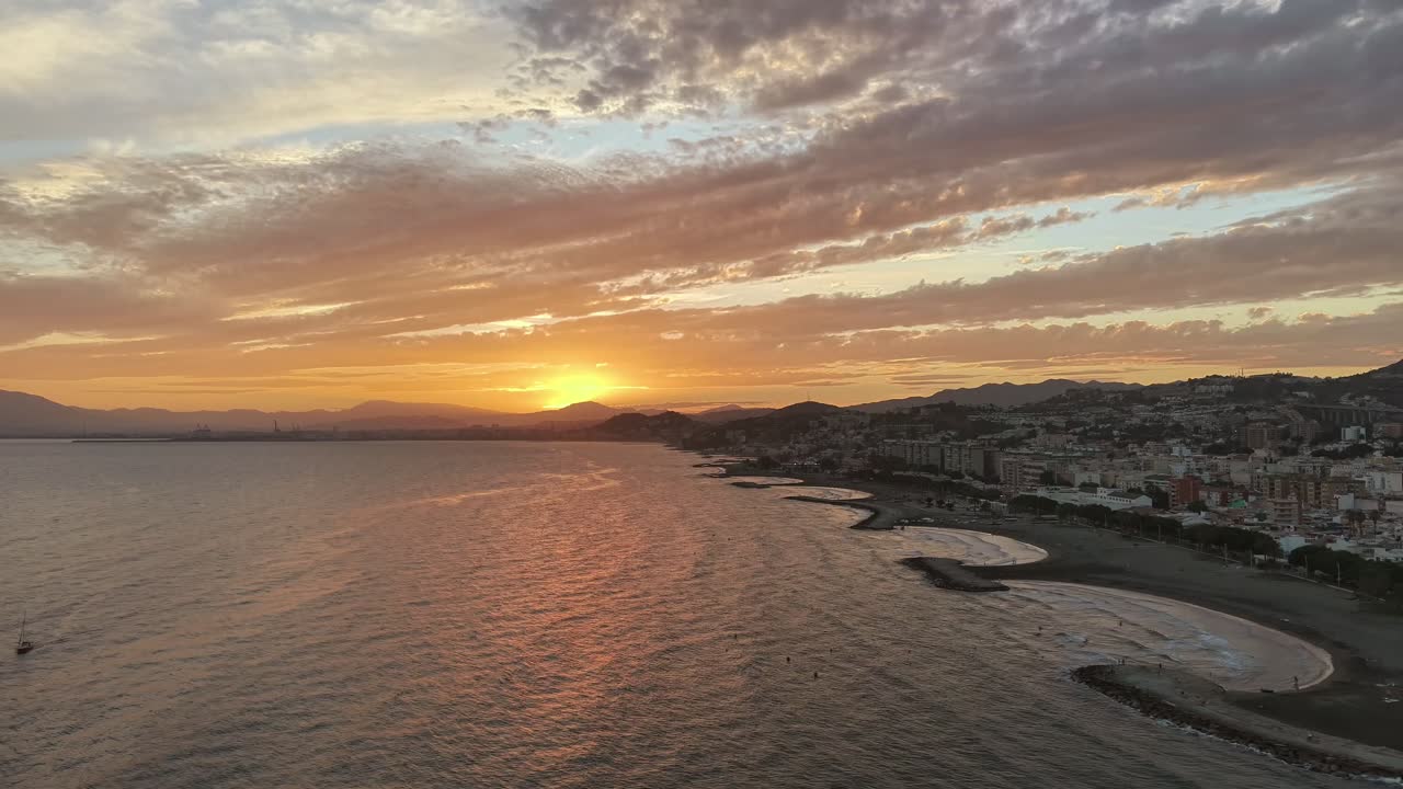Golden sunset over Malaga coast with calm sea and scenic landscape