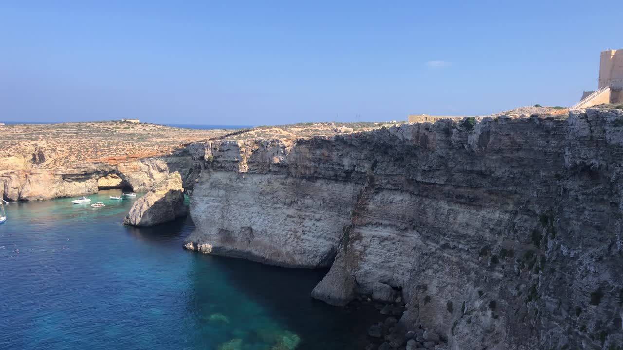 isola di comino colpo grandangolare panoramico della scogliera rocciosa con la baia del mare mediterraneo barca a vela di lusso ormeggiata