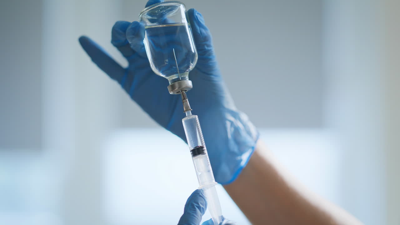 Nurse holding syringe vaccine closeup. Hospital infectious disease department