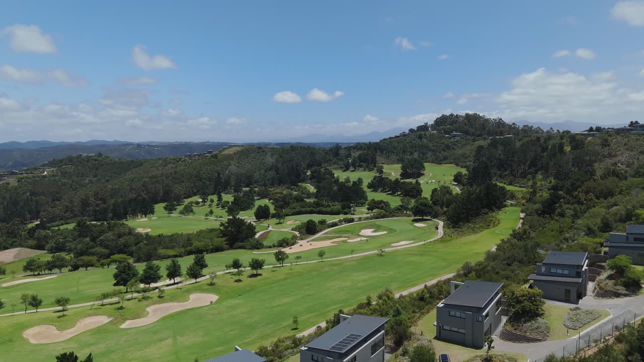 남아프리카의 가든 루트 (garden route) 에 자리 잡은 고급 골프 코스의 드론 풍경, 현대적인 주택, 경치 좋은 산, 풍요롭고 독점적이고 부유한 라이프 스타일을 특징으로합니다.