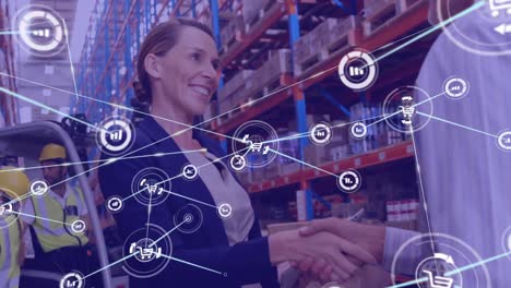 Network-of-digital-icons-against-caucasian-male-and-female-supervisor-shaking-hands-at-warehouse