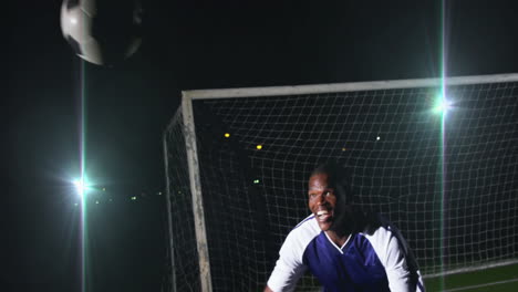 celebrating in front of goal at night, soccer player in blue jersey