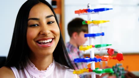 estudiante experimentando con un modelo de molécula en el laboratorio de la escuela