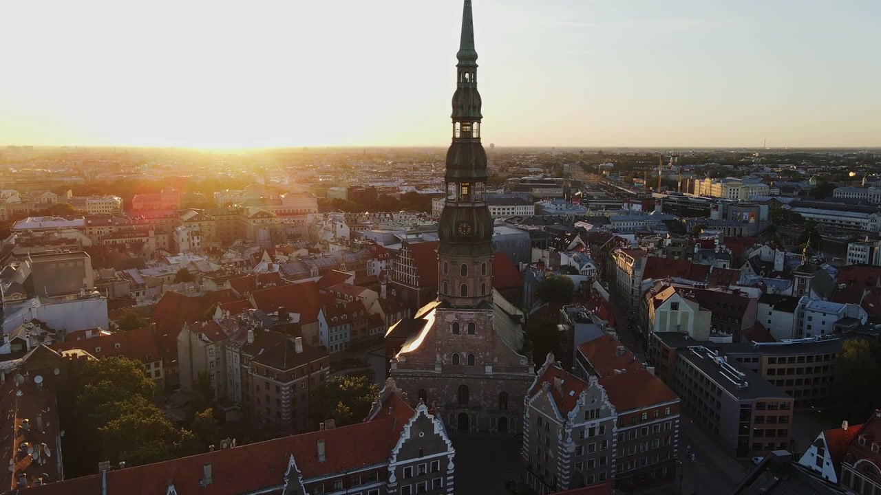 Alba dorata sulla Torre della Chiesa di San Pietro e sul centro storico di Riga, vista aerea