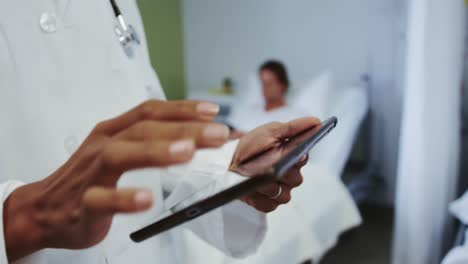 Close-up-of-African-american-female-doctor-using-digital-tablet-in-ward-at-hospital