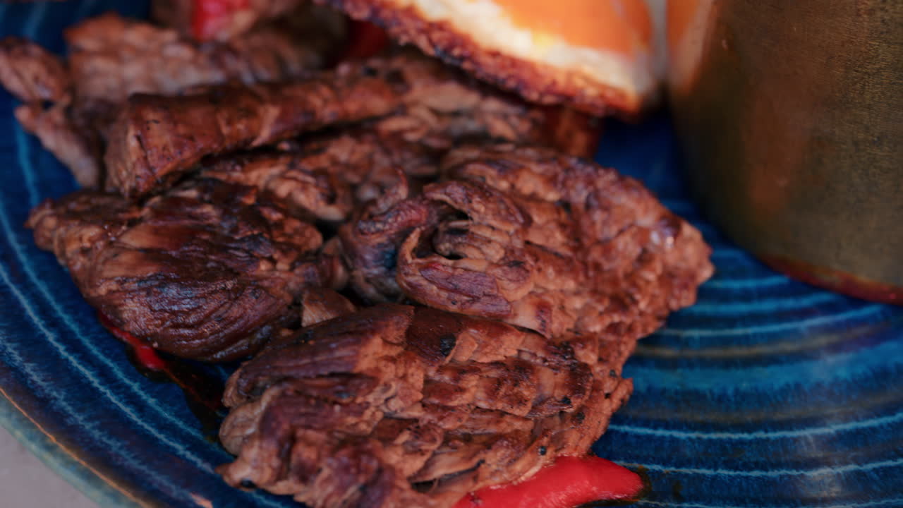 Close up of fried eggs with meat and a dip on a blue plate