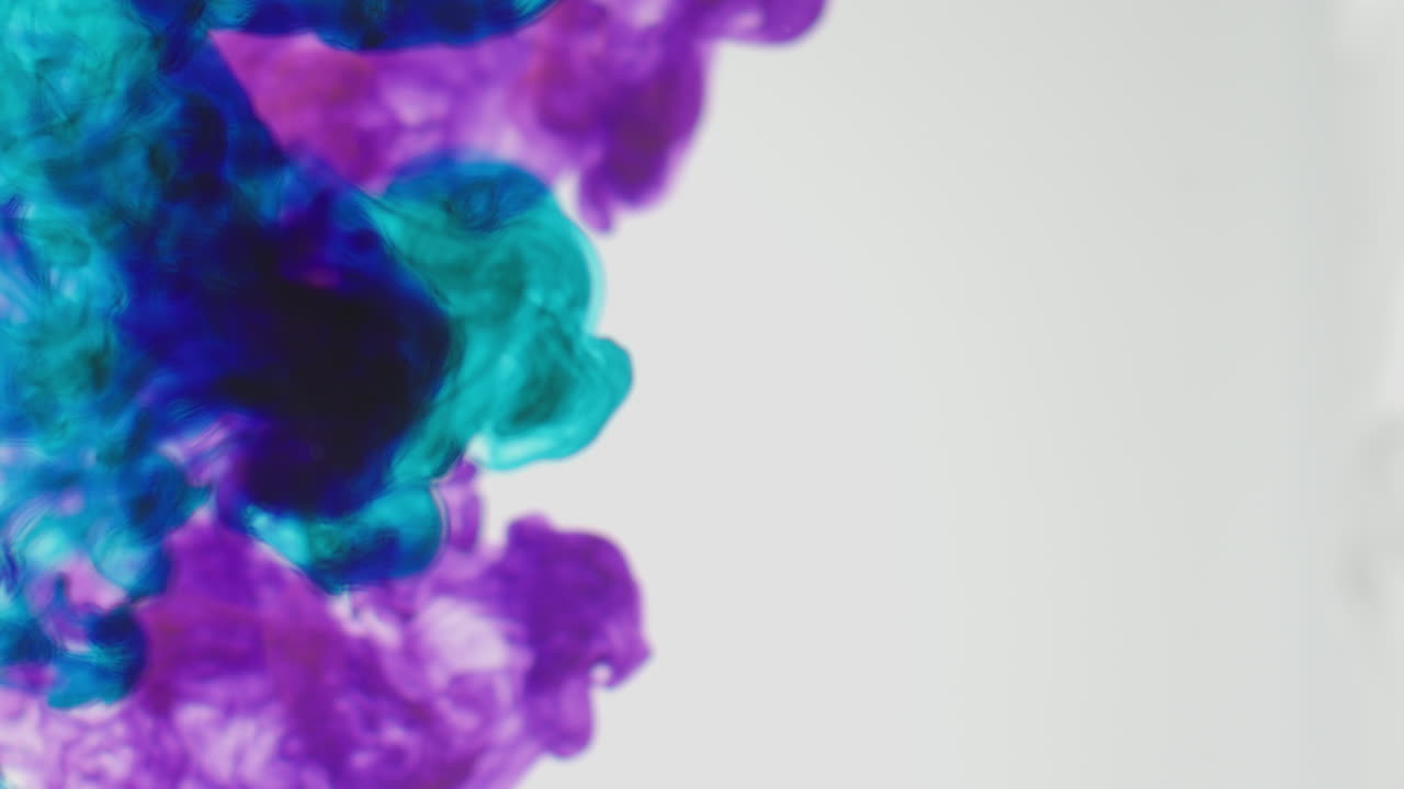 pintura o tinte púrpura y azul caído en el agua contra un fondo blanco para crear un fondo de humo de colores giratorios 4