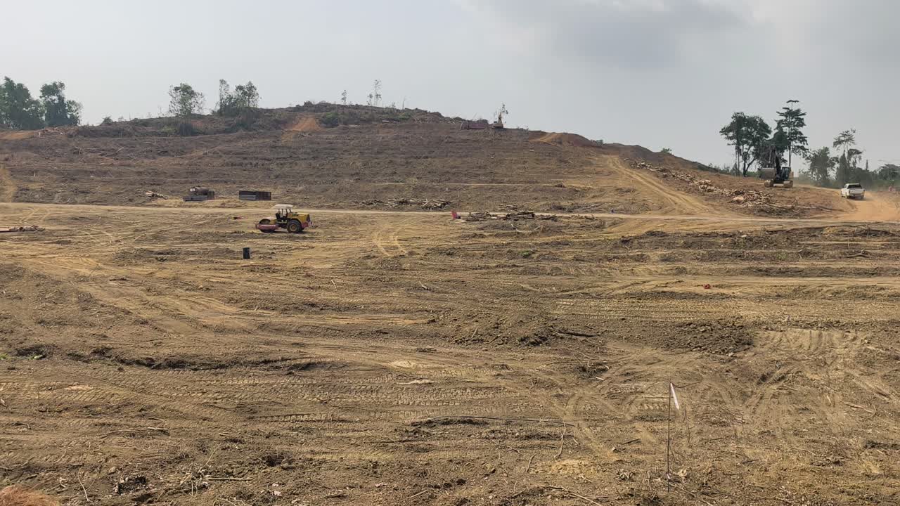 Maquinaria pesada desmata vastas áreas florestais durante obras de terraplanagem. A terra é despojada e nivelada para desenvolvimento. Este desmatamento cria um alto risco de erosão do solo e impacto ambiental.