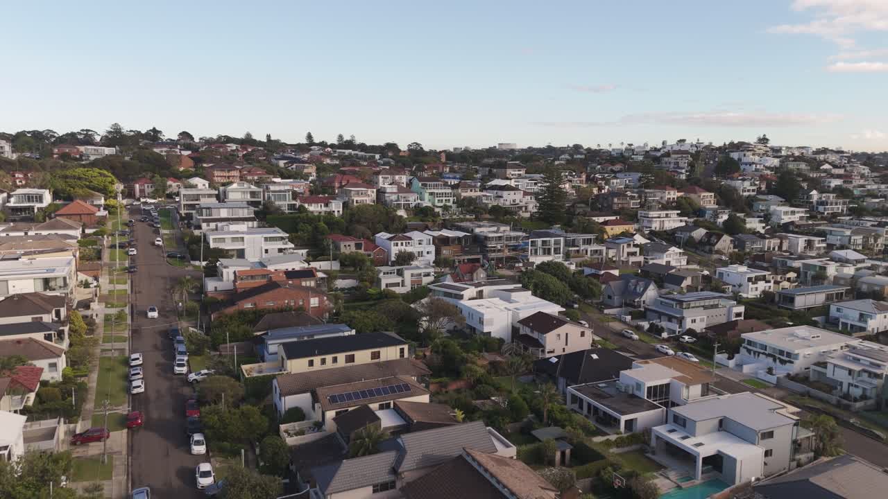 Aerial Low Flyover of Sydney Neighborhood Homes at Sunrise. Morning Light on Rooftops, Residential Housing and Properties in Australia, Captured in Smooth Forward Motion