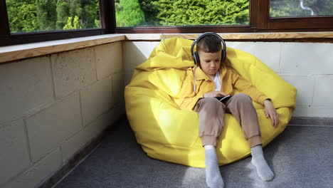 Niño-Sentado-En-Un-Hassock