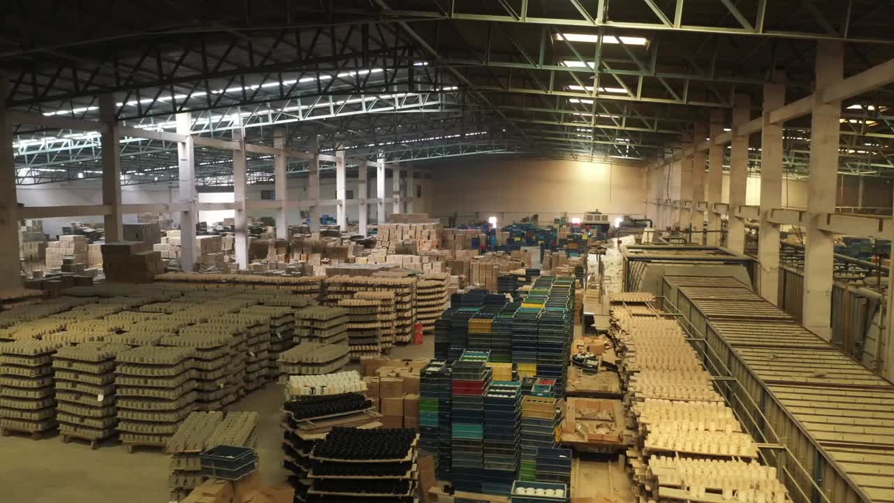 Magazzino di una fabbrica di ceramiche pieno di migliaia di tazze di ceramica impilate e casse organizzate