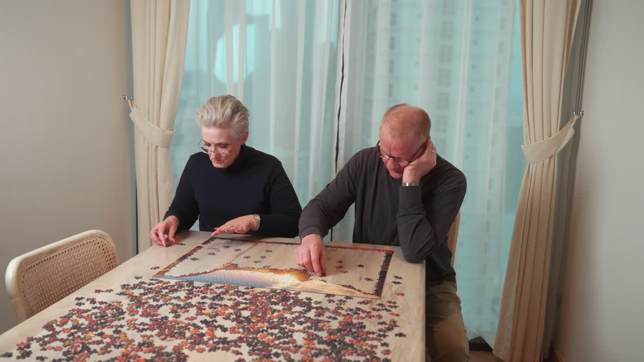 Couple enjoying senior years together and bonding while putting a puzzle together in their golden years
