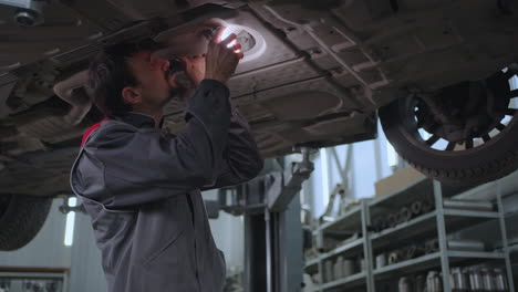 el mecánico automotriz inspecciona el coche antes de las reparaciones. condición técnica de la máquina. evaluación de la reparación