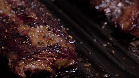 Closeup-Pan-Left,-Sizzling-steaks-with-sea-salt-almost-finish-broiling