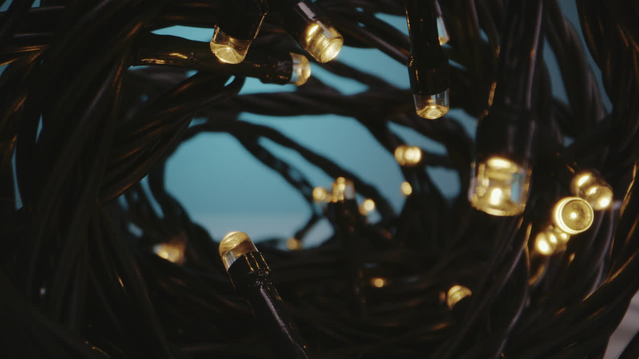 Close-up of tangled black string lights with warm yellow LEDs