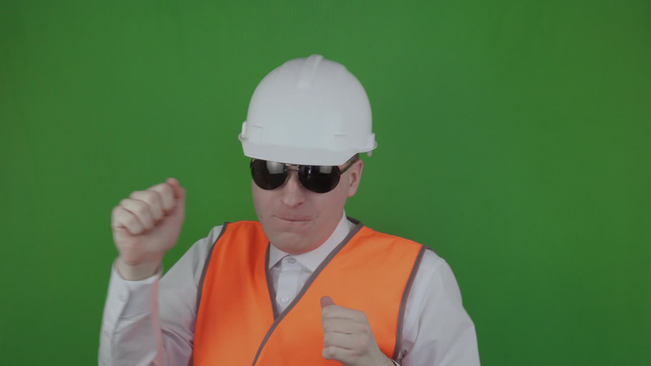 재미있고 행복한 엔지니어 또는 건설자가 춤을 추고 새로운 건설에 기합니다. chromakey. 재미있는 보스가 몸을 흔들고. 부동산 시장.  헬과 오렌지색 반사 베스트를 입은 수장.