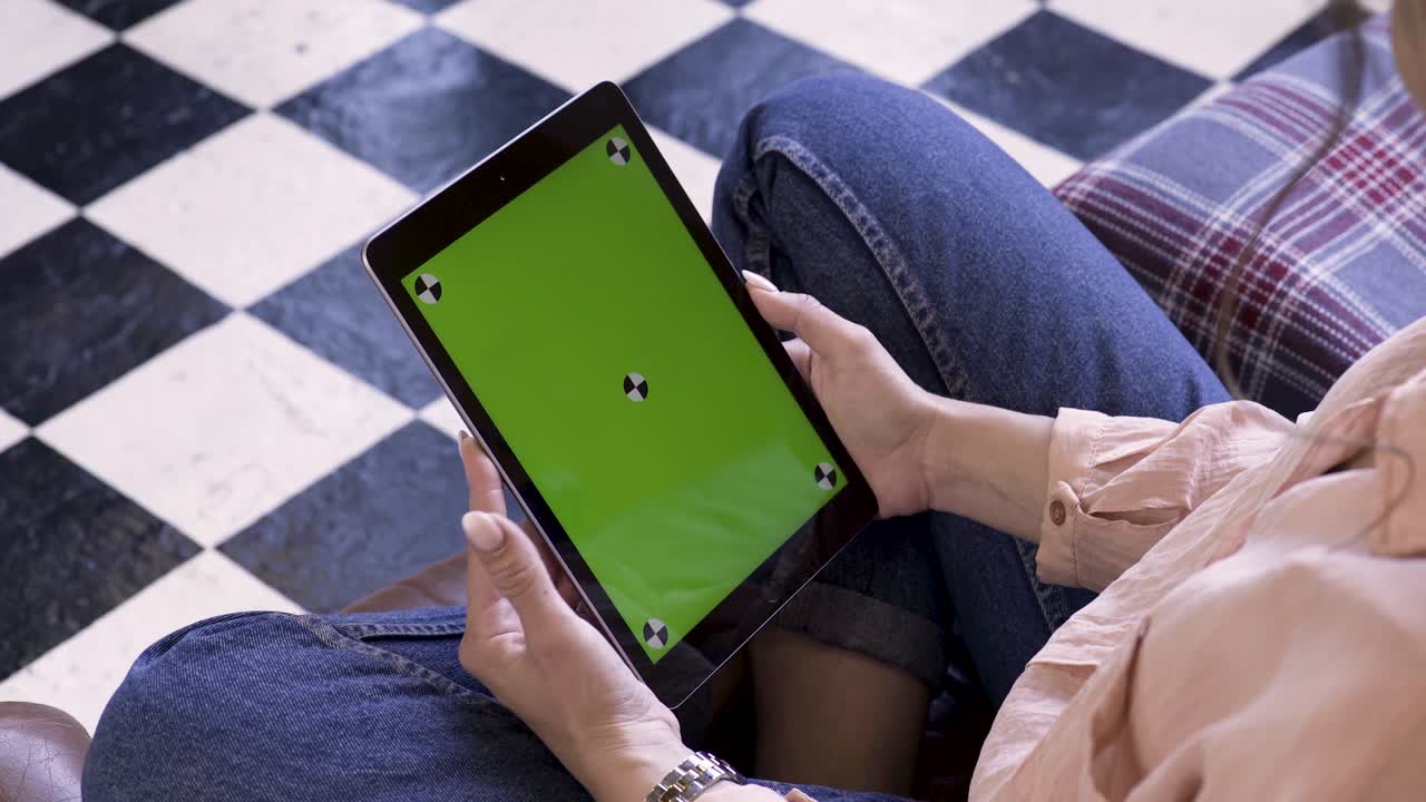 mujer sosteniendo una tableta con una pantalla verde