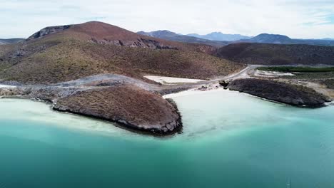 vista panorámica aérea sobre la hermosa costa con mar turquesa, paisaje seco y playa con una carretera costera en playa el tecolote baja california sur durante un emocionante viaje a través de méxico