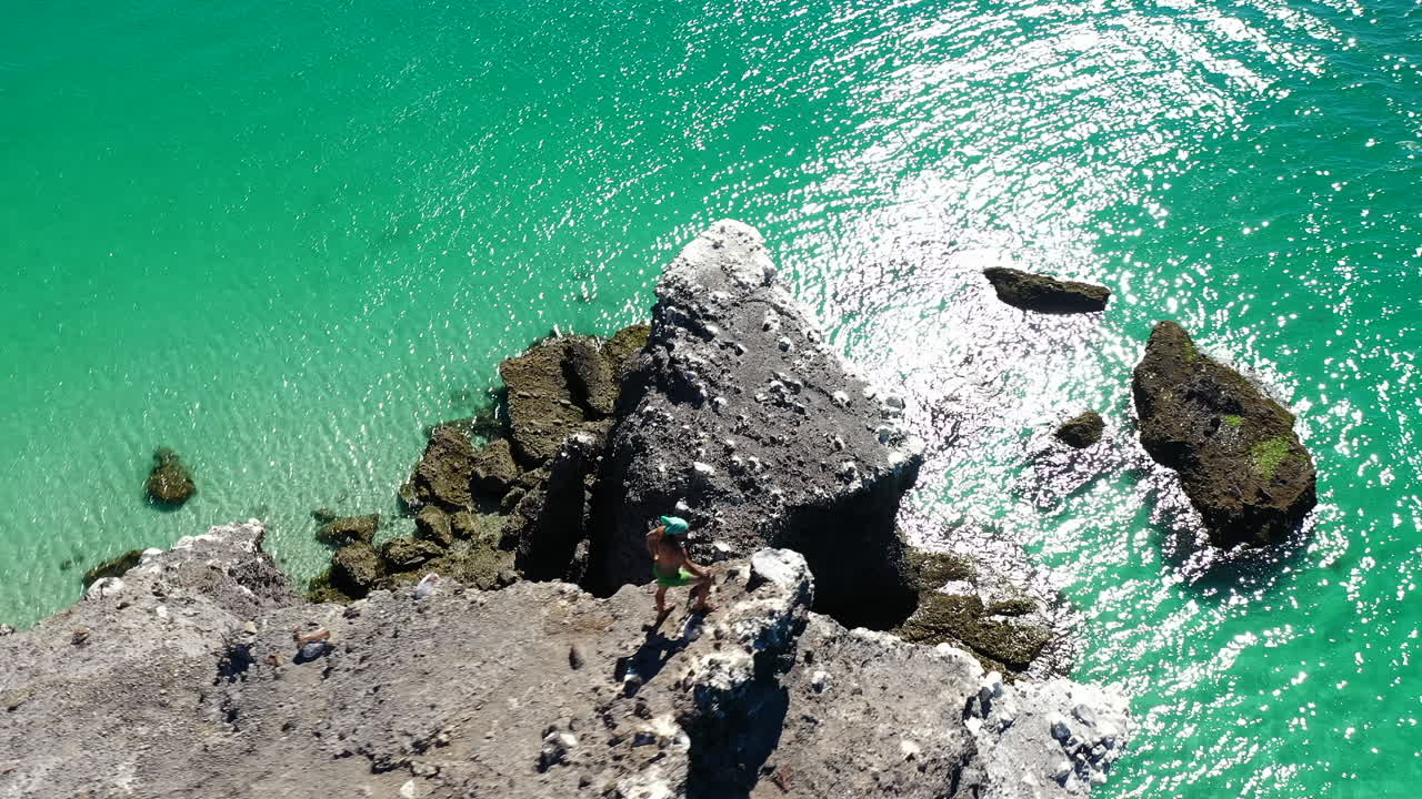 турист стоит у скалы на побережье пляжа баландра в ла-пасе, штат баха калифорния сур, мексика