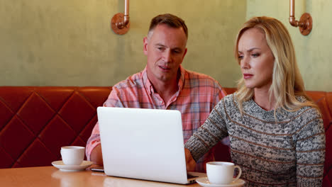 couple using laptop while having coffee 4k