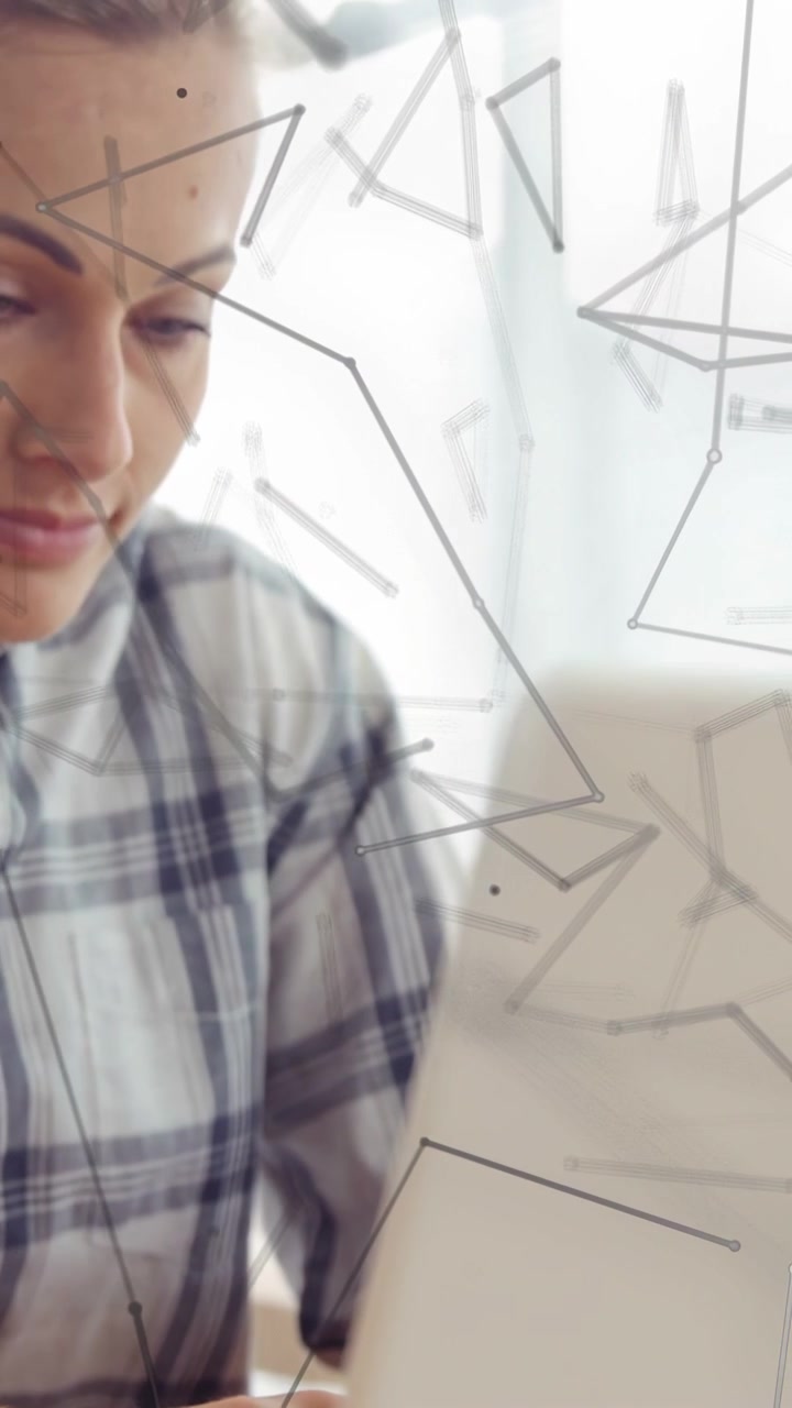 Video verticale: Mano che entra, lei che cerca i tasti, inclinando il laptop e ispezionando, con un'interfaccia tecnologica che oscura la vista.