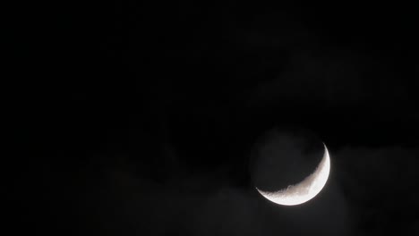 en el cielo nocturno se ve la media luna y las nubes que pasan