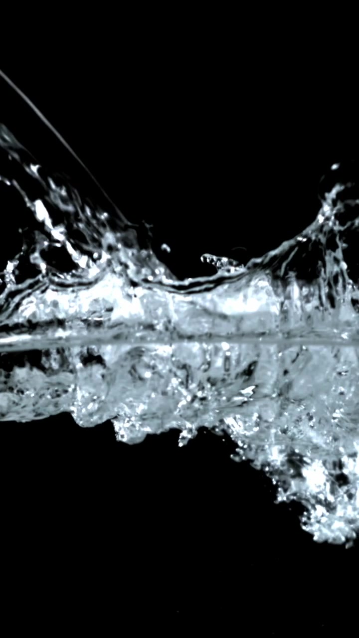 Acqua limpida che schizza e increspa al rallentatore su sfondo nero