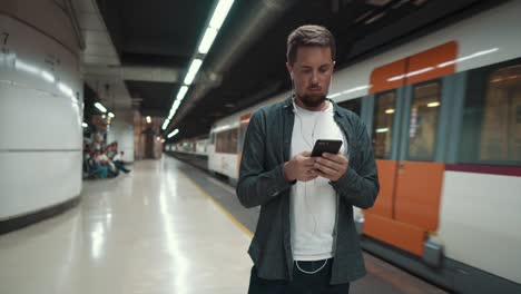 man using smartphone and listening to music on the subway