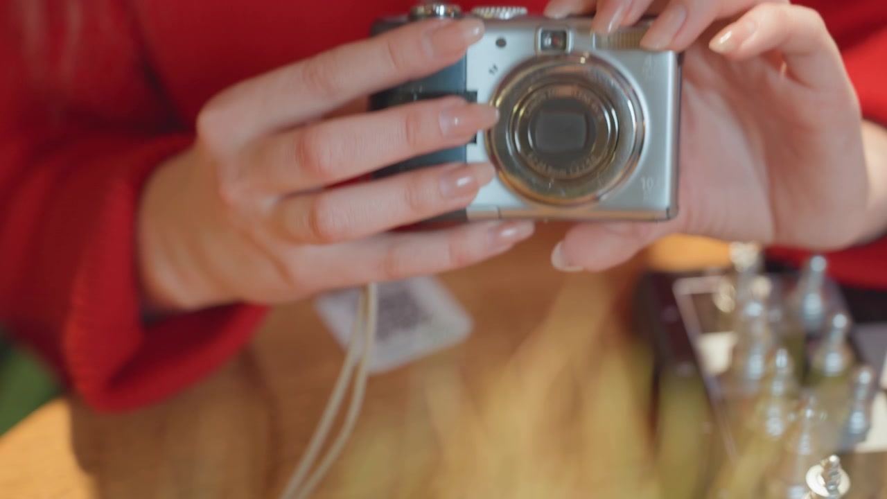 Mani di donna che regolano le impostazioni su una fotocamera digitale.
