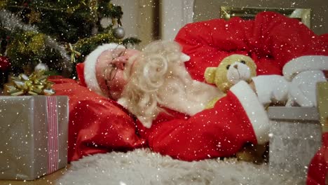 composición de video con nieve cayendo sobre santa durmiendo en el suelo al lado del árbol