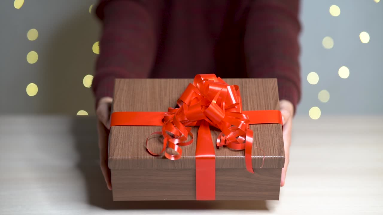 manos de mujer entregando un regalo de navidad