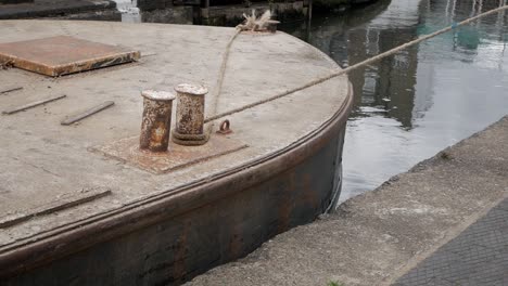 hopper narrowboat being roped to be pulled across canal lock